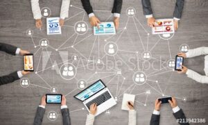 What is digital marketing? Business professionals collaborating with laptops, tablets, and smartphones connected through a digital network, illustrating online marketing and teamwork